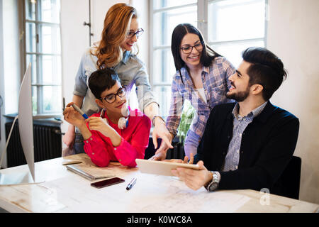 Group of young perspective designers discussing in office Stock Photo