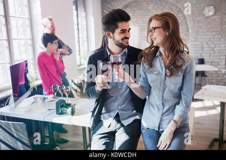 Happy young architects having break and drinking wine Stock Photo