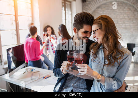 Happy young architects having break and drinking wine Stock Photo