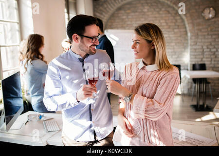 Happy young architects having break and drinking wine Stock Photo