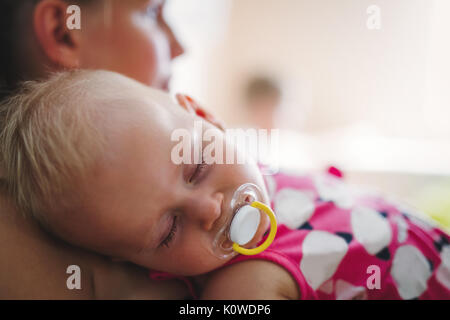 Young mother holding her sleeping newborn baby Stock Photo