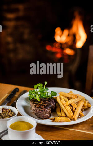 Steak and chips by the fireside Stock Photo
