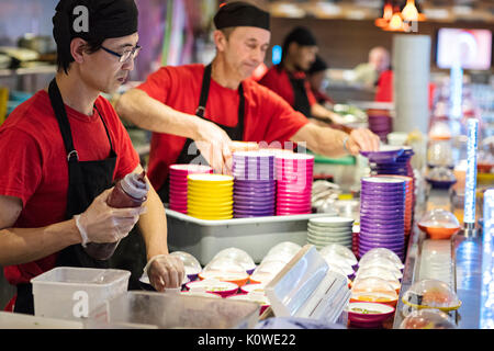 Busy production of sushi in Japanese restaurant Stock Photo