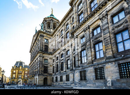 The Royal Palace in Dam Square in Amsterdam during early autumn as a huge flock of pigeons gather in front of the town hall Stock Photo