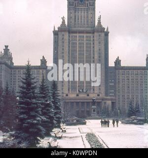 Snow-covered view of the Main Building of Moscow State University, on the Sparrow Hills campus outside Moscow, Soviet Russia, USSR, November, 1973. In the center foreground in front of the entrance is the statue of Mikhail Lomonosov, founder of the university. Stock Photo
