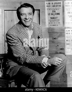 Portrait of an unidentified Hollywood actor smiling, with a poster in the background reading Eva La Gallienne in Hamlet, 1968. Stock Photo