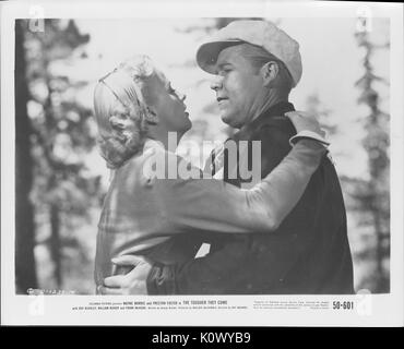 A movie still scene from 'The Tougher They Come' (1950 Columbia Pictures film), showing a man and a woman holding on to each other, with the woman looking up to her man as she says something serious to him, 1950. Stock Photo