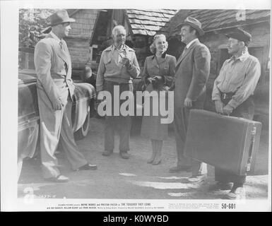 A movie still scene from 'The Tougher They Come' (1950 Columbia Pictures film), showing five adults standing outside a house, four men and a lady, amiably discussing matters of import, 1950. Stock Photo