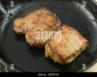 Premium Photo  Frying new york strip steak in cast iron frying pan over  the electric stove