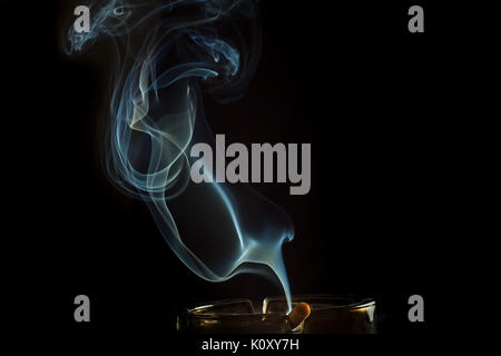 smoke from a cigarette on an ashtray Stock Photo