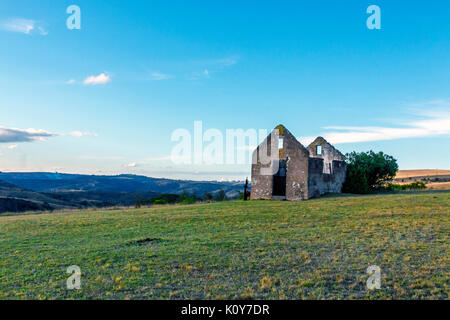 Rural old abandoned derelect farm building on dry winter landscape against blue cloudy sky in Lake Eland Game reserve in South Africa Stock Photo