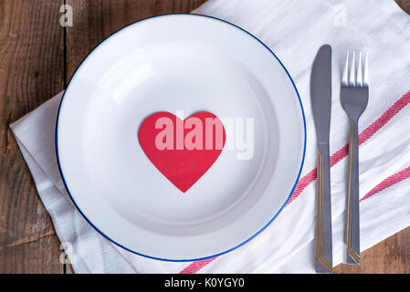 Concept diet and weight loss. Empty plate with red paper heart in the middle of the plate Stock Photo