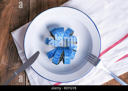 Concept diet and weight loss. Empty plate with measuring tape in the middle of the plate Stock Photo