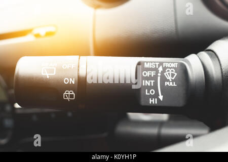 Closeup shot of male driver adjusting speed of screen wipers in car Stock Photo