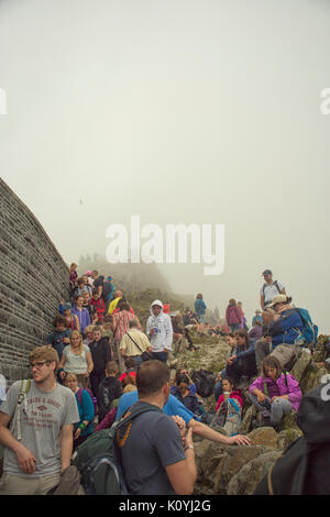 Crowds of hikers resting and taking in the view from the summit of Mount Snowdon in Wales, UK Stock Photo