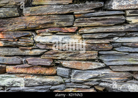 Stone wall made of various stones of different colors and shapes Stock Photo