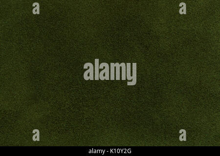 Background of dark green suede fabric closeup. Velvet matt texture of emerald nubuck textile. Stock Photo