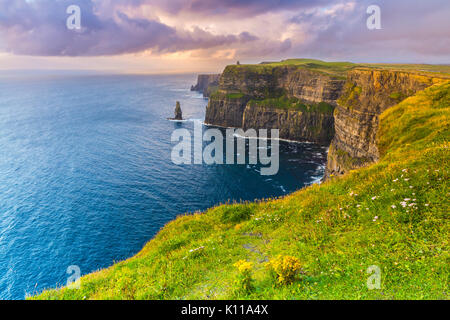 The Cliffs of Moher are located at the southwestern edge of the Burren region in County Clare, Ireland. They rise 120 metres (390 ft) above the Atlant Stock Photo