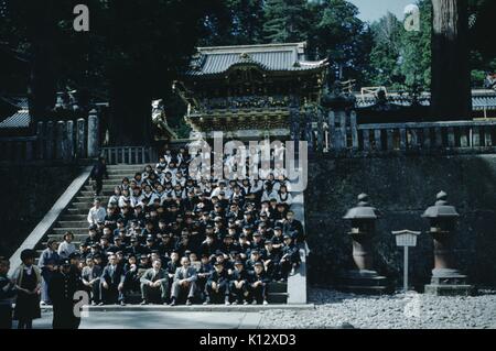Large group of Japanese people posing for a group photograph on the steps of a temple, Japan, 1952. Stock Photo