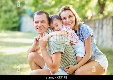 Happy family smiling playing in summer park.  Stock Photo