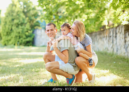 Happy family smiling playing in summer park. Stock Photo