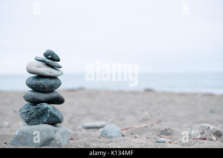 Monochrome, Serene, Blue Stacked rocks on a California beach symbolizing Peace, Balance, Meditation, and Mindfulness Stock Photo