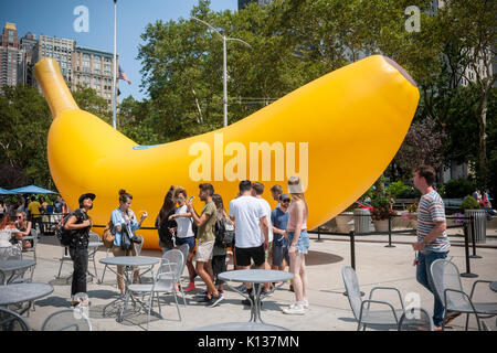 A giant inflatable banana stands in Flatiron Plaza in New York on Sunday, August 20, 2017 as part of the Chiquita 'Banana Sun' branding event. Chiquita has claimed the banana shaped sliver of the sun caused by the eclipse and re-named it the 'Banana Sun', also claiming that they are responsible for the eclipse. The tongue-in-cheek branding event also featured free eclipse watching glasses to passer-by. (© Richard B. Levine) Stock Photo