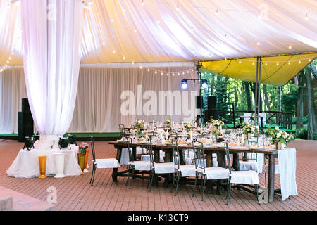 performance, wedding, party concept. beautiful space for celebrating one of the most important event, marriage. there are served tables under large te Stock Photo