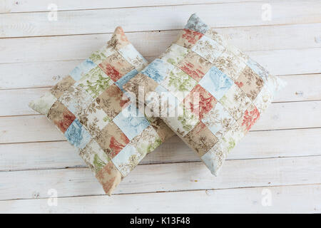 home, rest, hobby concept. two plumpy cosy pillows in pillowcases with exsquisite print consist of many square zones and prints of threes, flowers and Stock Photo