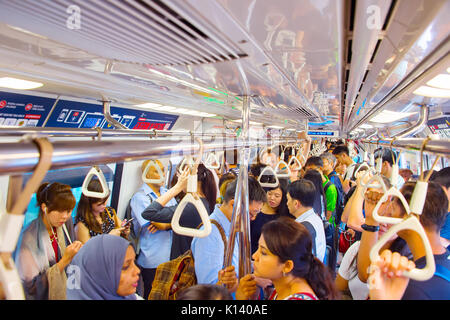SINGAPORE - JAN 13, 2017: Passengers in Singapore Mass Rapid Transit (MRT) train. The MRT has 102 stations and is the second-oldest metro system in So Stock Photo
