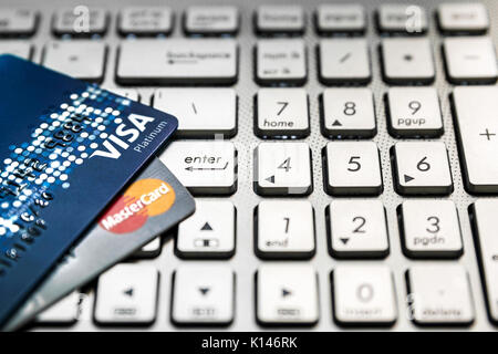 Bangkok, Thailand - August 24, 2017: Close up shot of 2 credit cards VISA and Mastercard on laptop computer with enter button focusing. Stock Photo