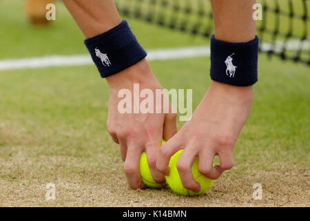 A ball boy picks up some tennis balls at the Wimbledon Championships 2017 Stock Photo