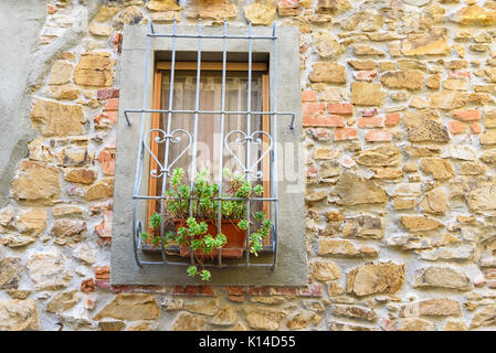 window with iron grating on old stone wall Stock Photo