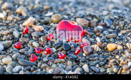 Pebble stones on the beach. Background of sea stones.  stones with hearts. Red heart of the stones Stock Photo