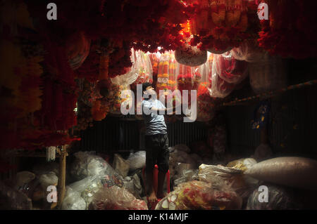 A worker in Agartala prepares flower garlands made with plastic flowers before ensuing festivities of  Durga puja. Durga Puja, also called Durgotsava and Navaratri, is an annual Hindu or Bengali Hindu festival in the Indian subcontinent that reveres the goddess Durga.  Durga Puja is particularly observed by Hindus in eastern and northeastern states of India, in Bangladesh and in Nepal where it is called Dashain.It is a major festival in the Shaktism tradition of Hinduism across India and Shakta Hindu diaspora. (Photo by Abhisek Saha/Pacific Press) Stock Photo