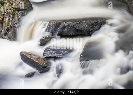 Rocks in flowing water, Rhaeadr Ddu waterfalls, Ganllwydd, Coed Ganllwydd National Nature Reserve, Snowdonia National Park, Gwynedd, Wales, UK Stock Photo