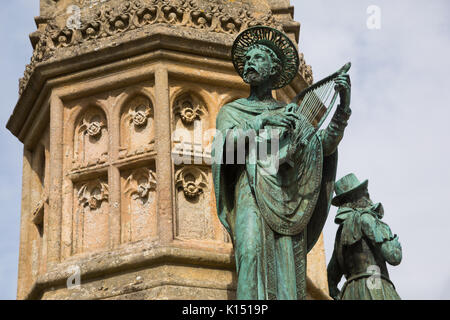 Religious statue of St Aldhelm playing harp on the Digby Memorial outside the Abbey church of St Mary the Virgin (Sherborne Abbey), Sherborne, Dorset Stock Photo