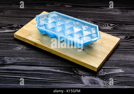 A blue plastic ice cube tray with frost on it isolated over a white  background, Stock image