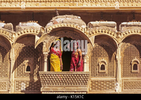 Women on intricately carved sandstone balcony in Jaisalmer Fort, Jaisalmer, Rajasthan, India Stock Photo