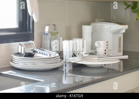 White ceramic set and stainless kitchen utensils on the counter Stock Photo
