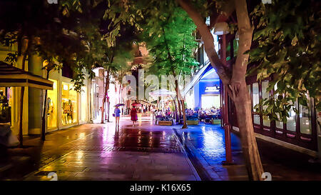 An evening, soft focus shot of people enjoying a rainy night in the Plaka district of Athens Greece Stock Photo
