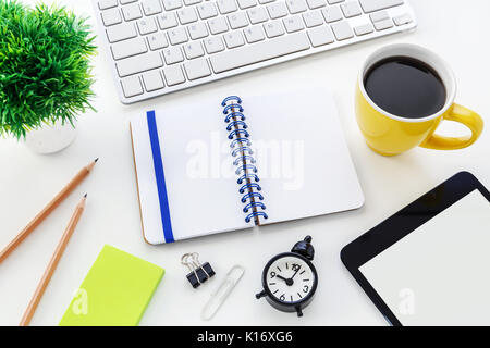 Modern office desk with computer blank notebook clock and coffee cup Stock Photo