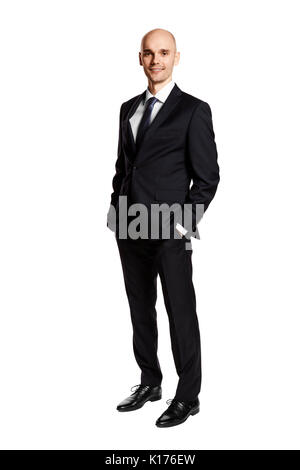 Full length portrait of young man i black suit. Hands in pockets. Isolated on white. Stock Photo