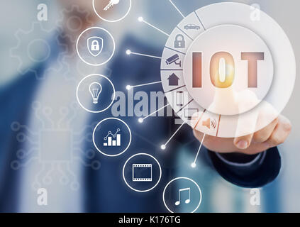 Internet of Things technology with connected objects, hand touching button with text IOT on AR (Augmented Reality) interface with icons Stock Photo