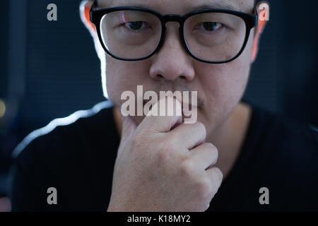 Close up portrait of young hesitant asian men in thinking . Stock Photo
