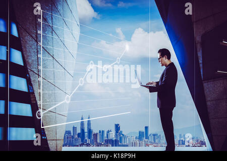Businessman using laptop with graph statistical analysis ,Business success concept. Stock Photo