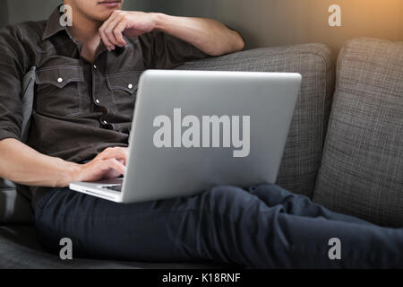 Businessman works on the sofa at home. Work searching for new idea creative and drinking hot coffee feeling think hard. Stock Photo