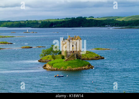 Castle Stalker, tower house / keep on tiny island in Loch Laich near Port Appin, Argyll, Scotland, with small boat and small lighthouse nearby Stock Photo