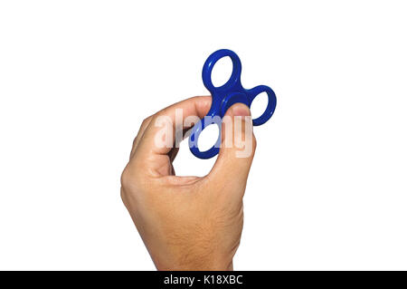 Male hand holding a blue spinner on white isolated background. Powerful spinner, Twister for hands entertainment rotating toy. Stock Photo