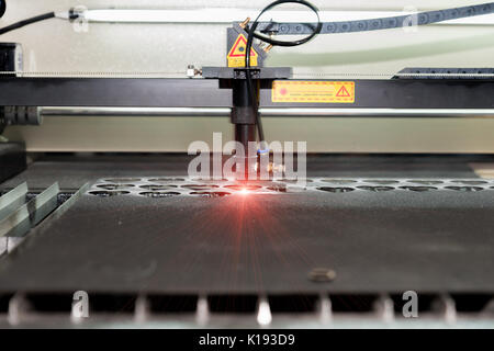 High precision CNC laser cutting metal sheet in factory. Stock Photo
